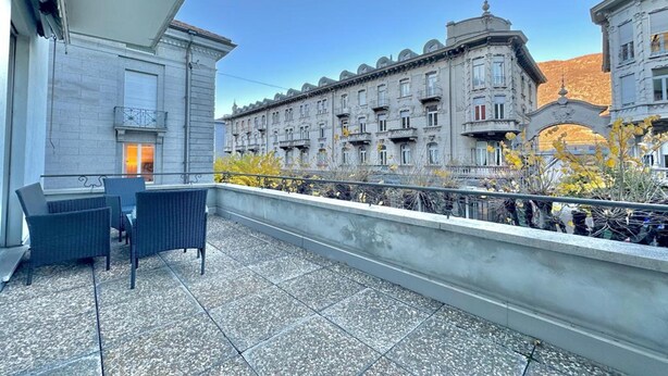 A balcony with outdoor furniture, a view of historic buildings, and a clear sky. - Bellinzona in Centro (Bellinzona)