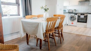 Enjoy meals at the dining table for four, surrounded by comfortable seating.