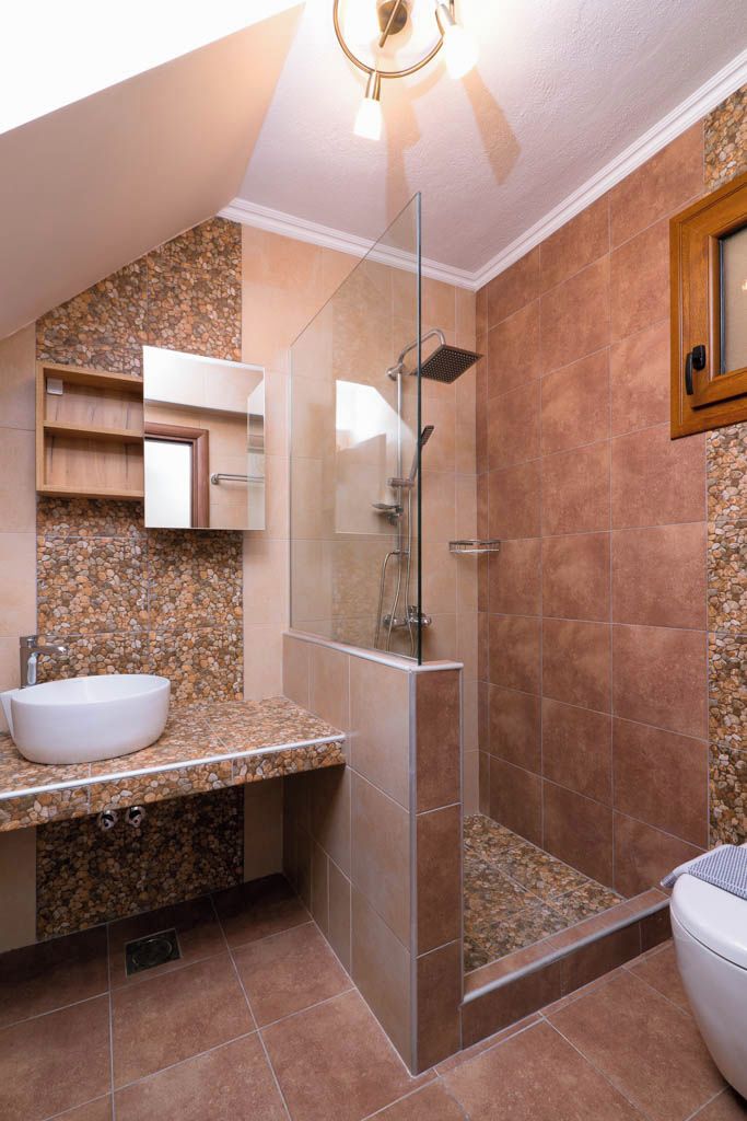 A bathroom with a glass-enclosed shower, a white sink, and a vanity with a mirror.