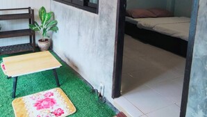 A small room with a bed, a bench, a potted plant, and a small table. - Mon Nao  (Mae Rim)