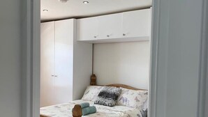 A bedroom with a wooden bed, white walls, and a ceiling with recessed lighting. - London Retreat at Hindsley's Place (London)