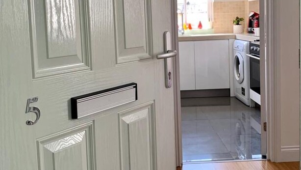 A hallway leading to a kitchen with a washing machine and a coffee maker. - London Retreat at Hindsley's Place (London)