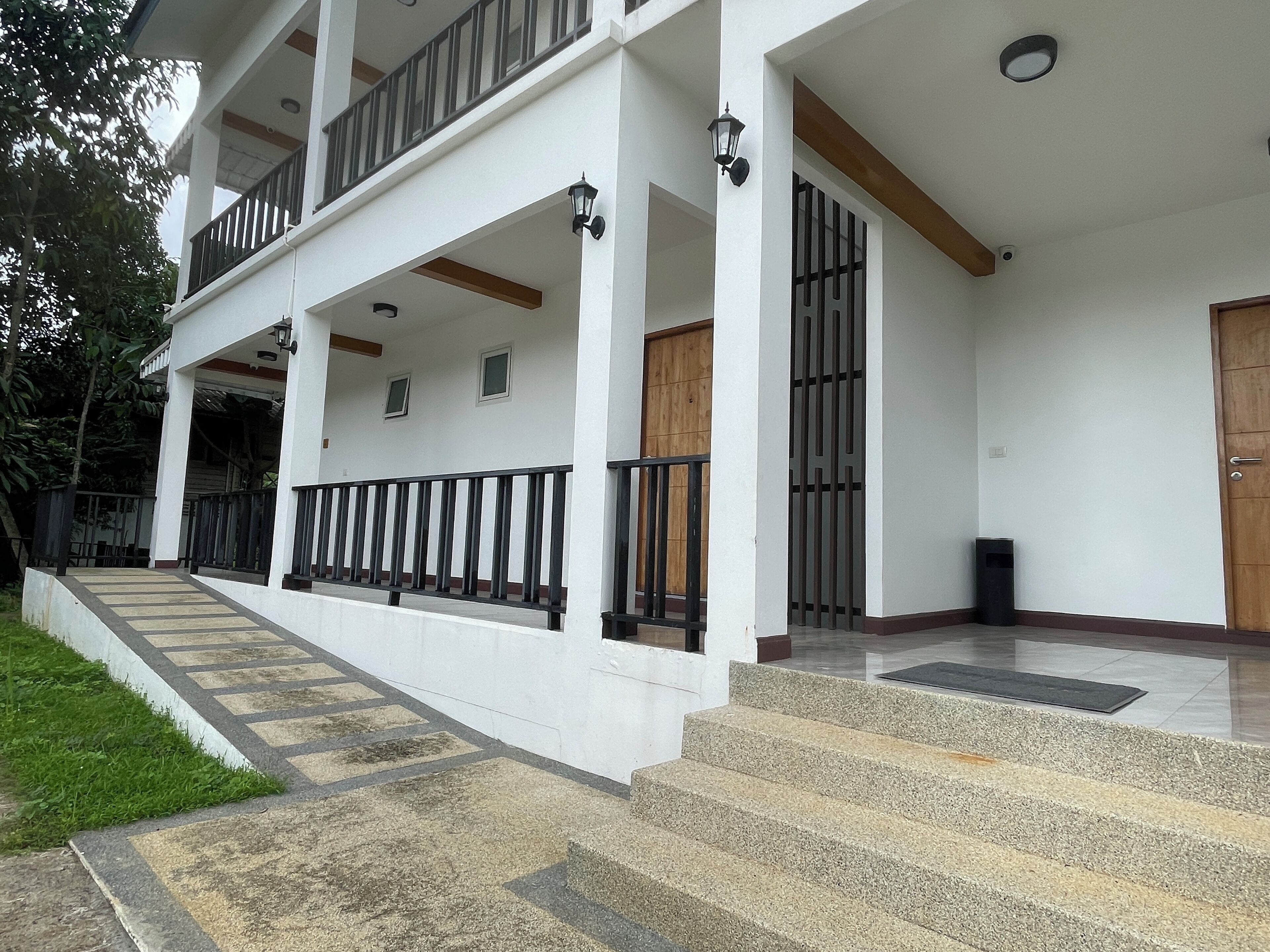 A two-story building with a balcony, a staircase, and a door.