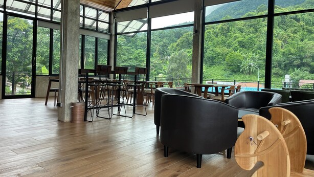 A spacious indoor area with large windows offering a view of lush greenery and mountains. - DOI LUANG SCENE (Chiang Dao)