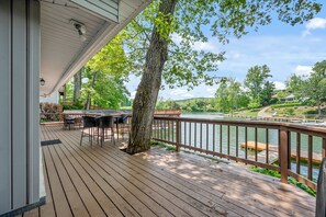 A wooden deck with outdoor seating, overlooking a river and greenery. - The Lake Effect House (Dublin)
