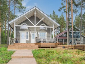 A cabin with a wooden deck, a covered porch, and a large window. - Levähdys by Interhome (Joensuu)