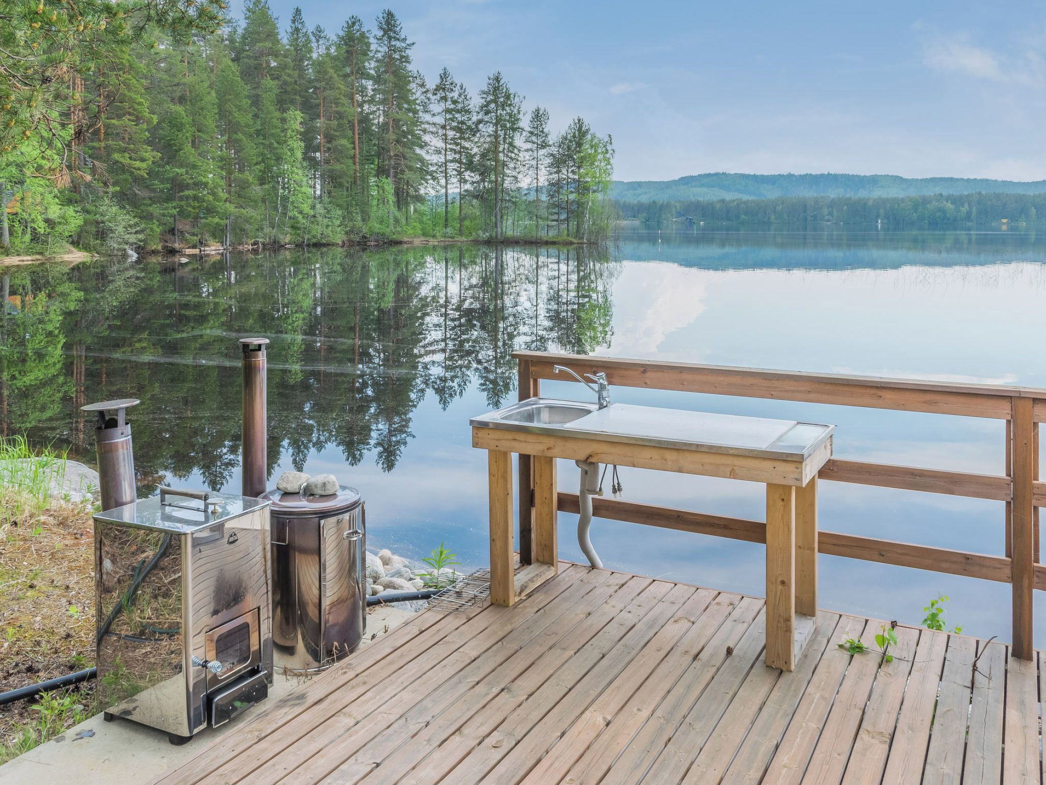 A wooden dock with a bench and a portable stove.