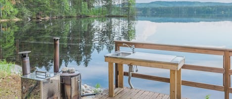 A wooden dock with a bench and a portable stove.