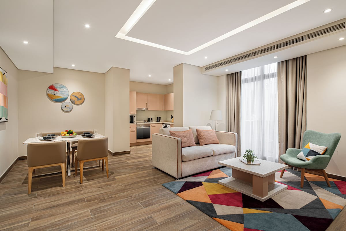 A modern living room with a sofa, coffee table, and dining area.