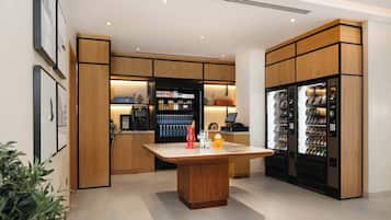 A modern kitchen with wooden cabinetry, a central island, and vending machines.