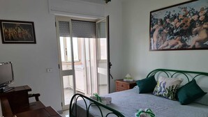 A bedroom with a bed, a desk, a chair, a painting, and a sliding door to a balcony. - Bellavista, apartment sea view with garage (Otranto)