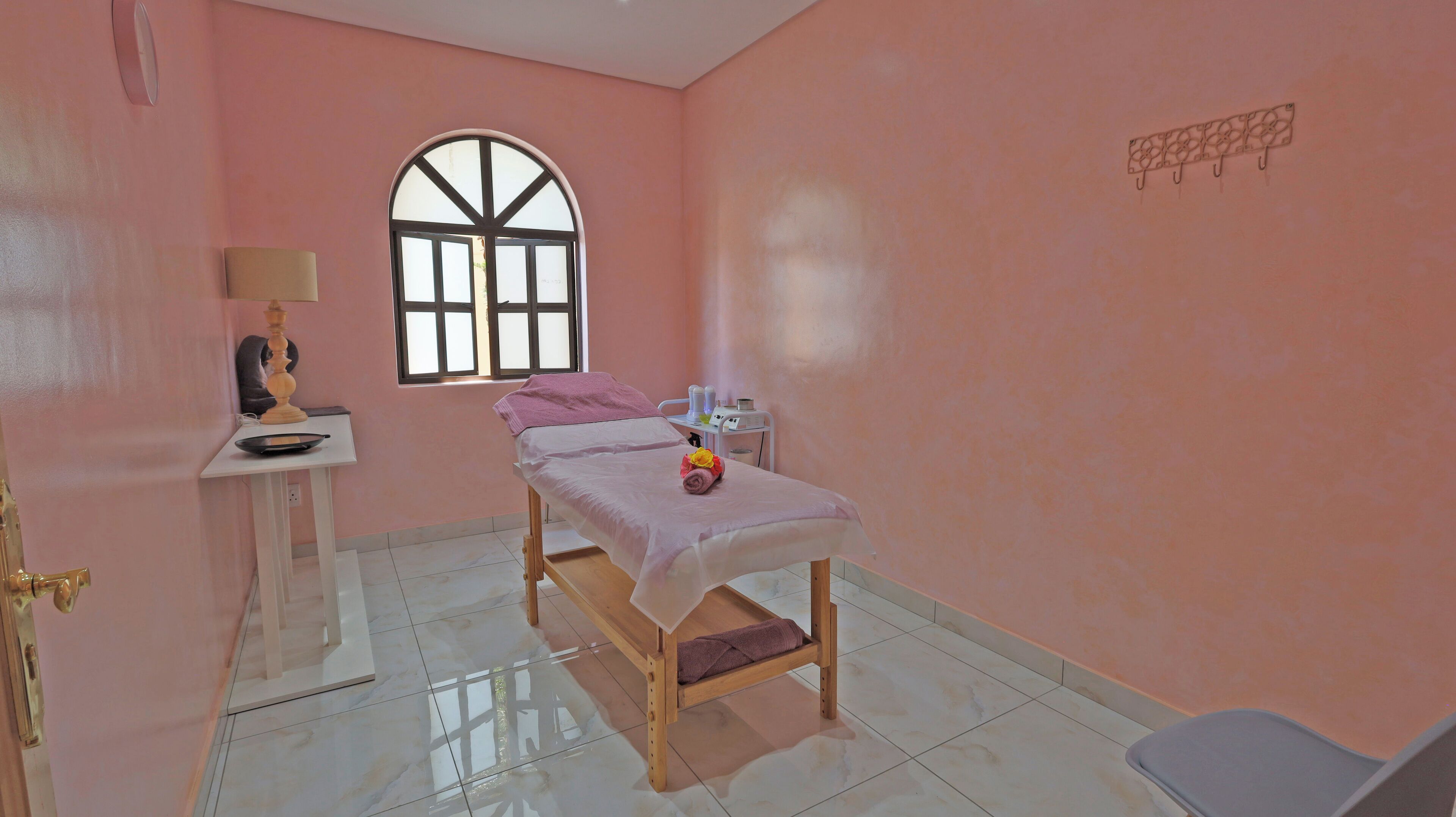 Una habitación con una cama, una mesita de noche con lámpara, una ventana y una silla.