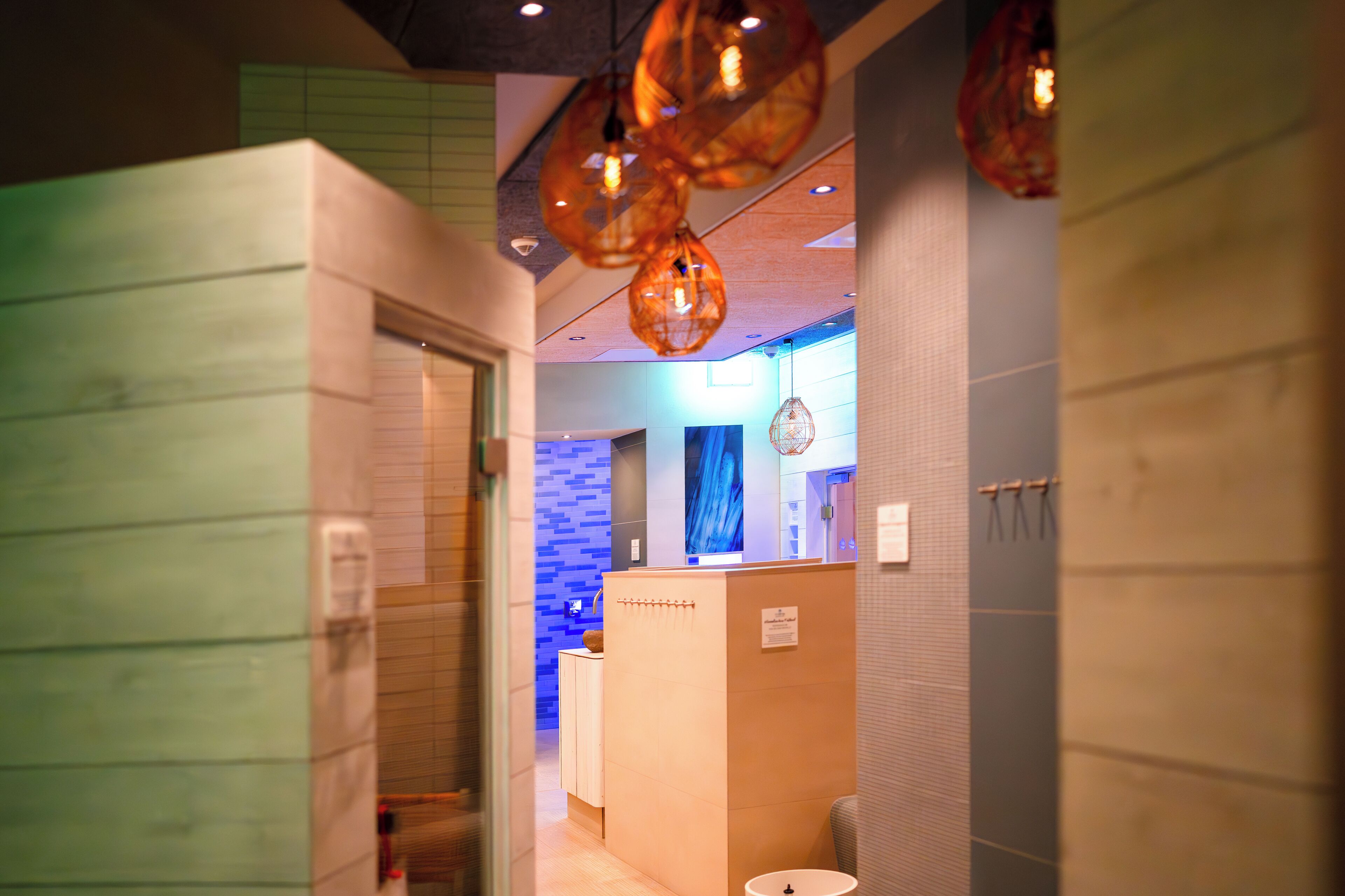 A modern bathroom with a reception desk, a blue wall, and a hanging light fixture.