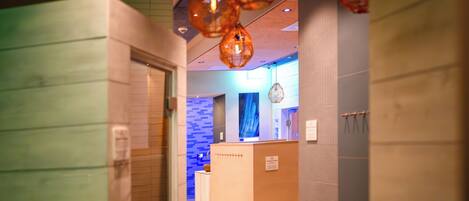 A modern bathroom with a reception desk, a blue wall, and a hanging light fixture.