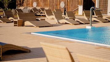 Un espace aménagé au bord de la piscine, avec des chaises longues et une piscine.