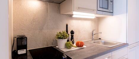 A modern kitchen with a built-in microwave, a stove, and a sink.