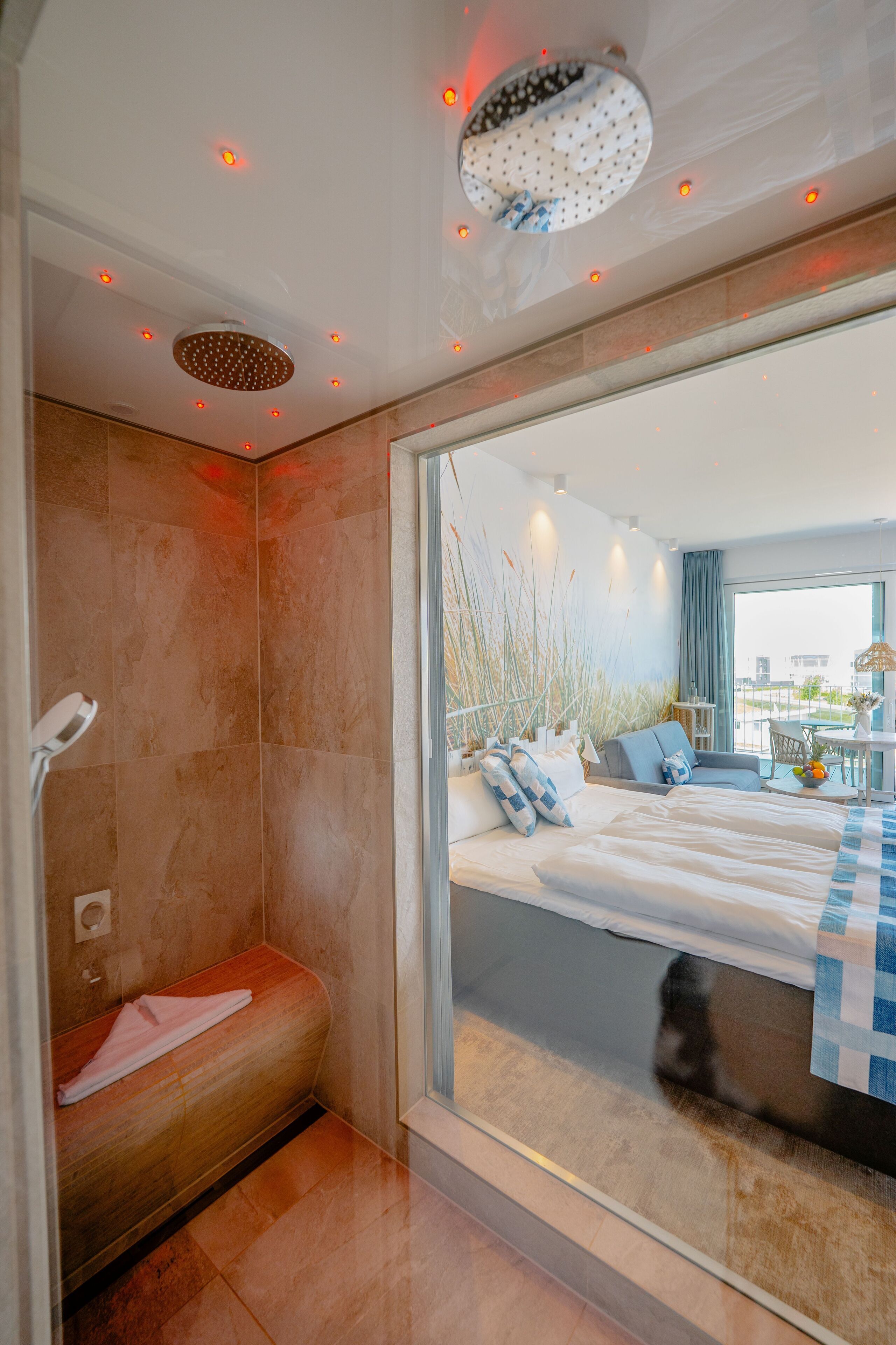 A modern hotel room with a large bed, a seating area, and a view of the city.