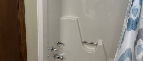 Una ducha con tres cabezales de ducha manuales.