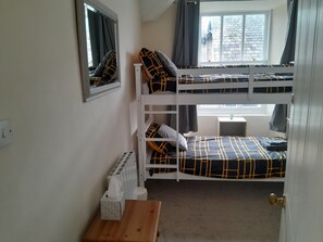 A bunk bed room with a mirror, a small table, and a window with curtains. - Hi Ho Steps Bowness On Windermere Apartment (Windermere)