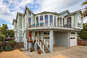 Een huis met twee verdiepingen, een balkon, een garage en een trap naar de bovenverdieping.