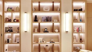 A well-organized bookshelf with multiple shelves, each containing various decorative items and books. - A LUXURIOUS RETREAT WHERE HISTORY MEETS CONTEMPORARY DESIGN AT RUE DU TEMPLE  (Paris)