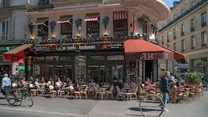 An outdoor café with tables and chairs, a covered seating area, and a building with a sign that reads "LIFE DU TEMPLE - RESTAURANT". - A LUXURIOUS RETREAT WHERE HISTORY MEETS CONTEMPORARY DESIGN AT RUE DU TEMPLE  (Paris)