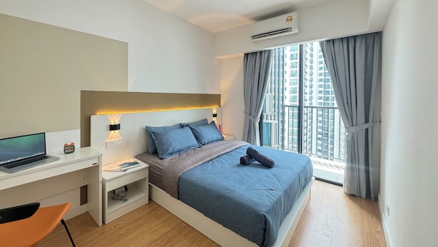 A modern hotel room with a bed, desk, and chair.