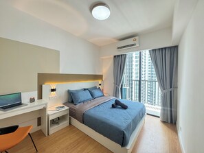 Una habitación de hotel moderna con cama, escritorio y silla.