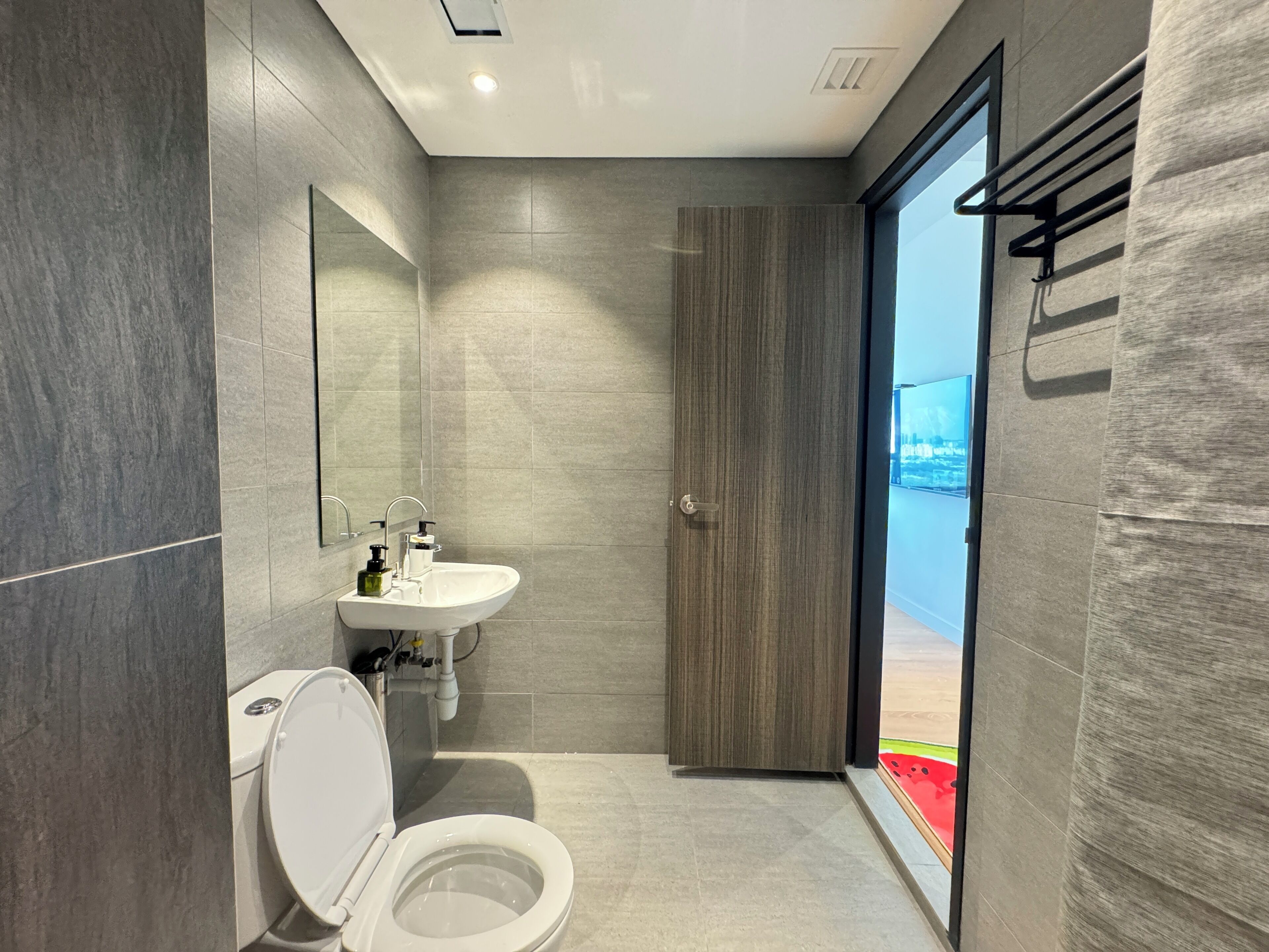 A modern bathroom with a toilet, sink, and mirror.