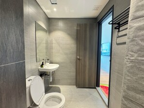 A modern bathroom with a toilet, sink, and mirror.