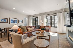 Relax in the cozy living room with a comfortable sofa, armchair, and fireplace.