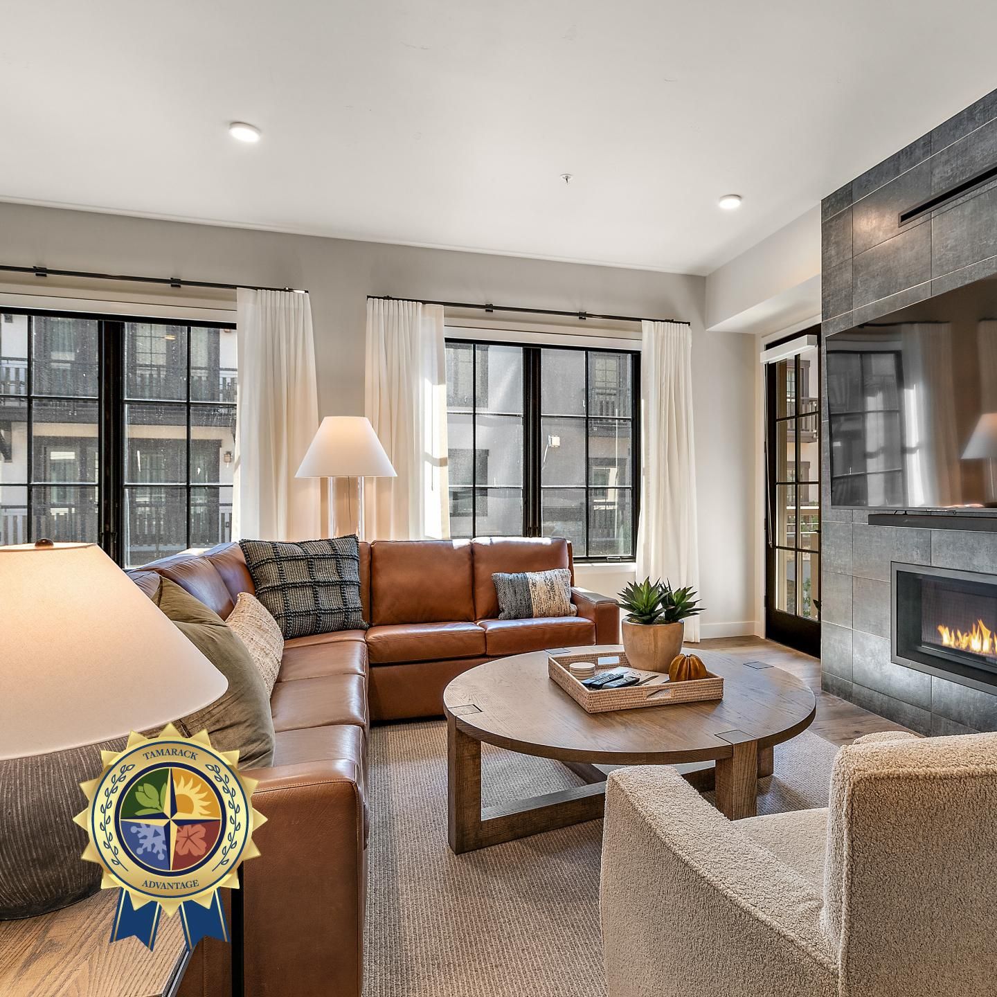 A modern living room with a leather sofa, a round coffee table, and a fireplace.