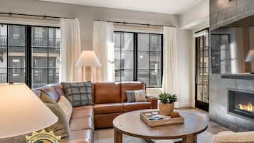 A modern living room with a leather sofa, a round coffee table, and a fireplace.