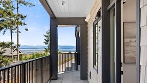 Een balkon met uitzicht op zee en bergen.