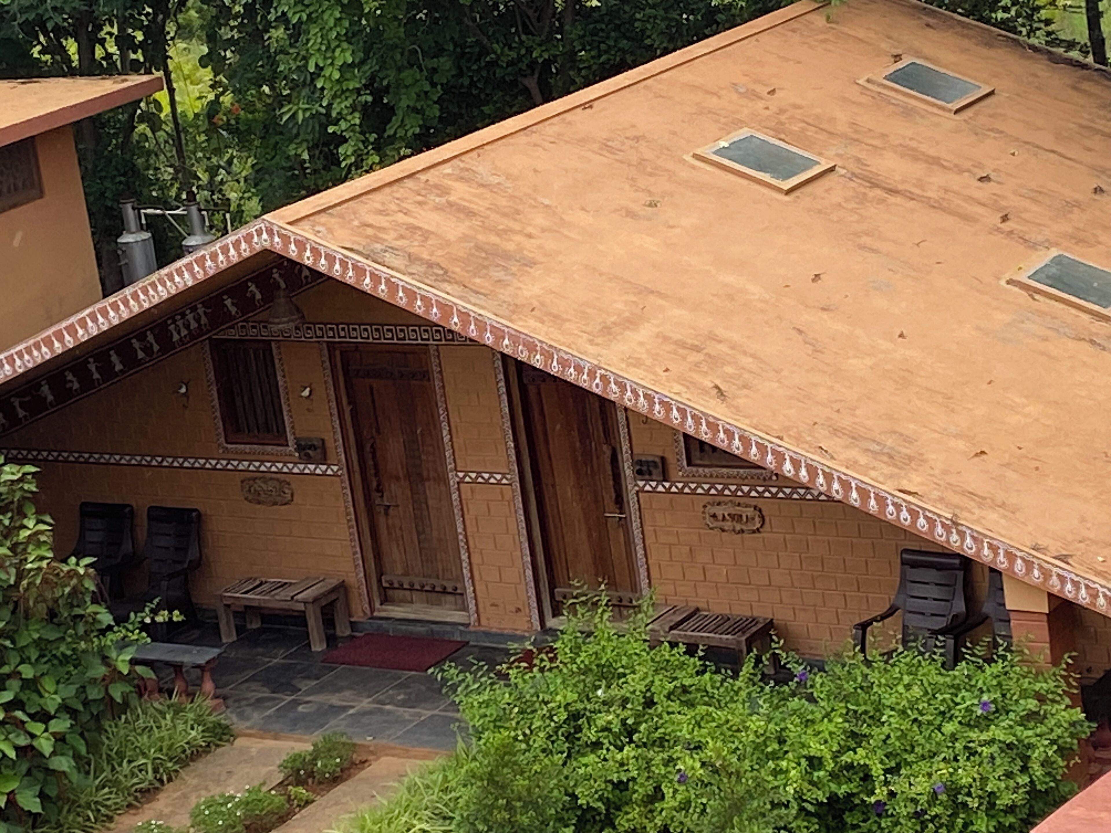 A traditional house with a sloped roof, a wooden door, and a small porch area.
