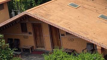 A traditional house with a sloped roof, a wooden door, and a small porch area.