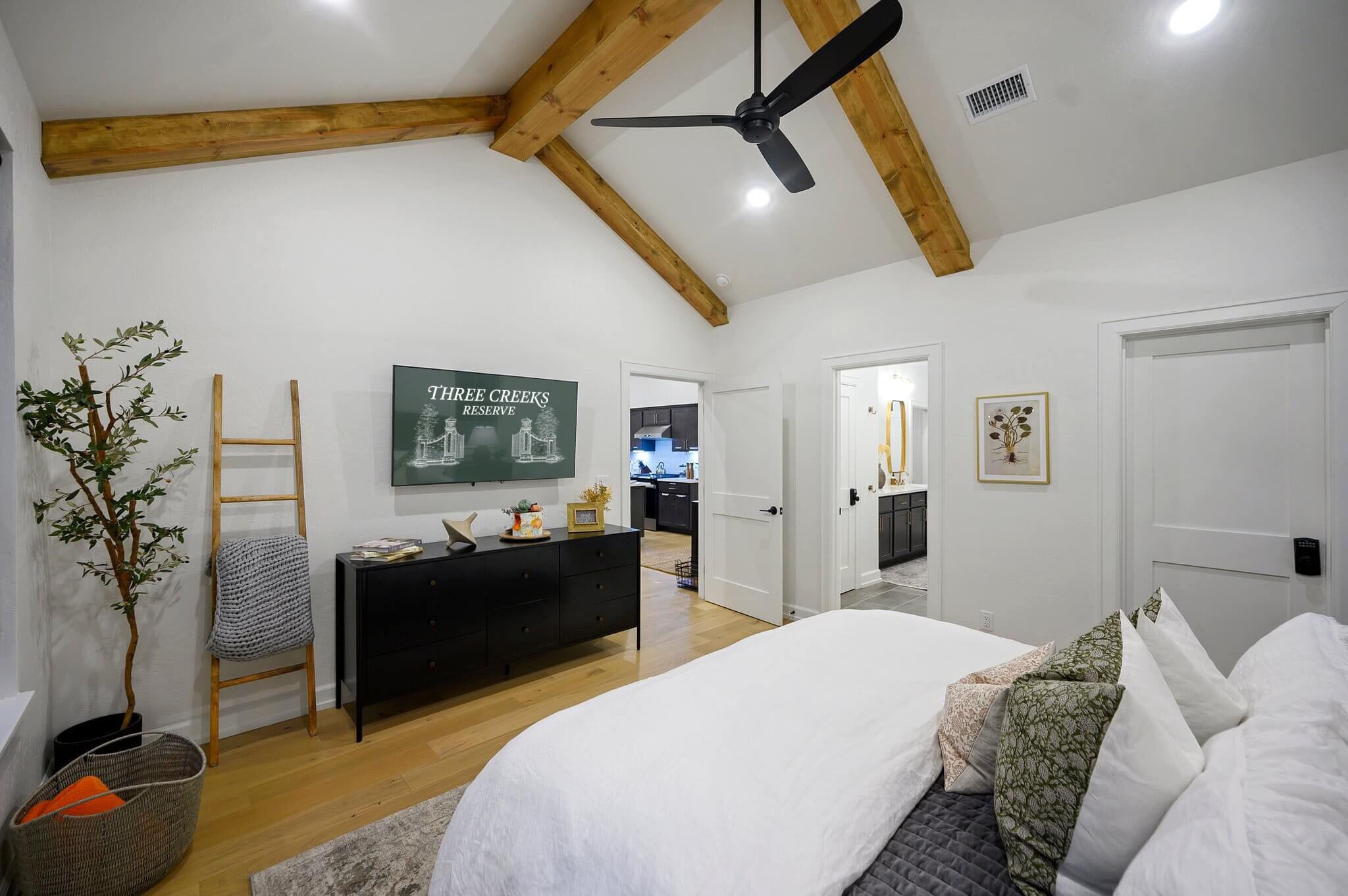 A bedroom with a bed, a dresser, a ladder, a plant, and a sign on the wall.