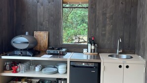 Una cocina compacta con una parrilla empotrada, un lavamanos y un lavavajillas.