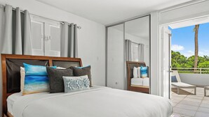 A bedroom with a large bed, a sliding door to a balcony, and a view of greenery outside. - Retiro del Sol | Your Perfect Caribbean Getaway (Dorado)