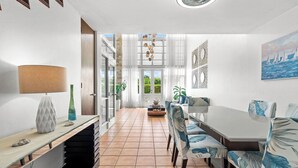 A modern dining area with a long table, chairs, and a lamp. - Retiro del Sol | Your Perfect Caribbean Getaway (Dorado)