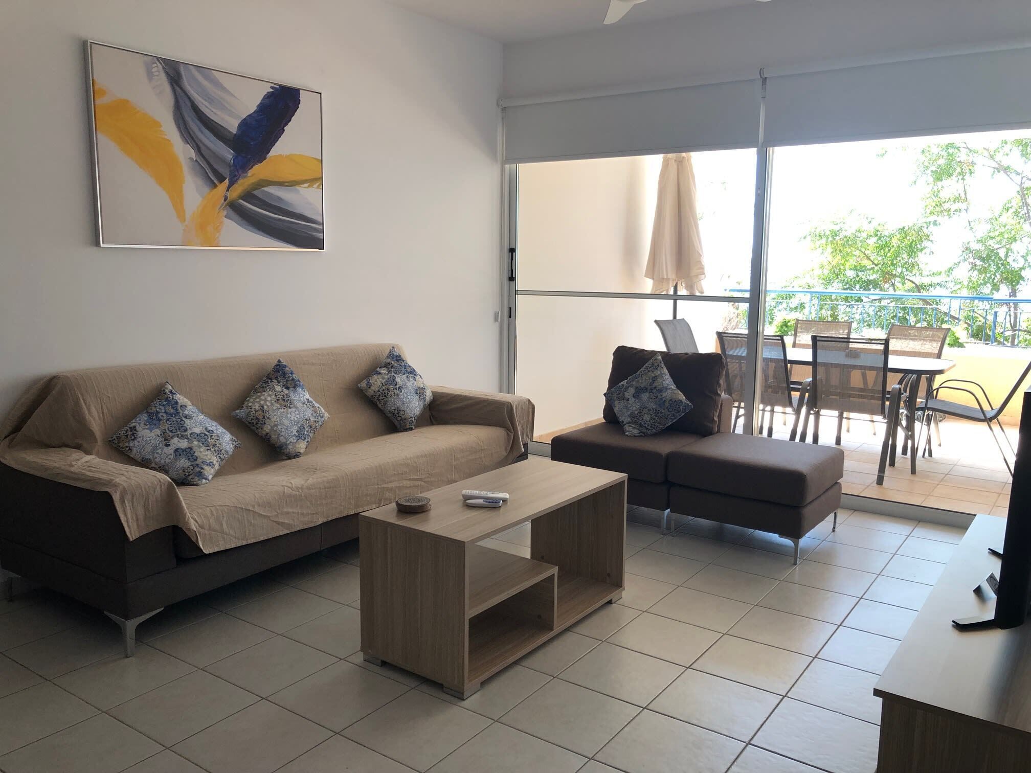 A modern living room with a sofa, a coffee table, and a TV stand.