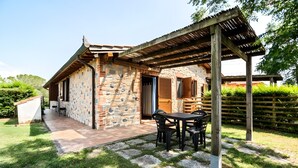 Une maison en pierre dotée d’un patio, d’un espace salon extérieur et d’une pergola.