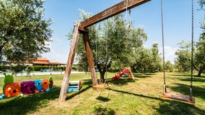 Une aire de jeux avec des balançoires et une structure colorée.