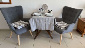 Une table à manger avec deux chaises, un petit objet décoratif et un miroir au mur.