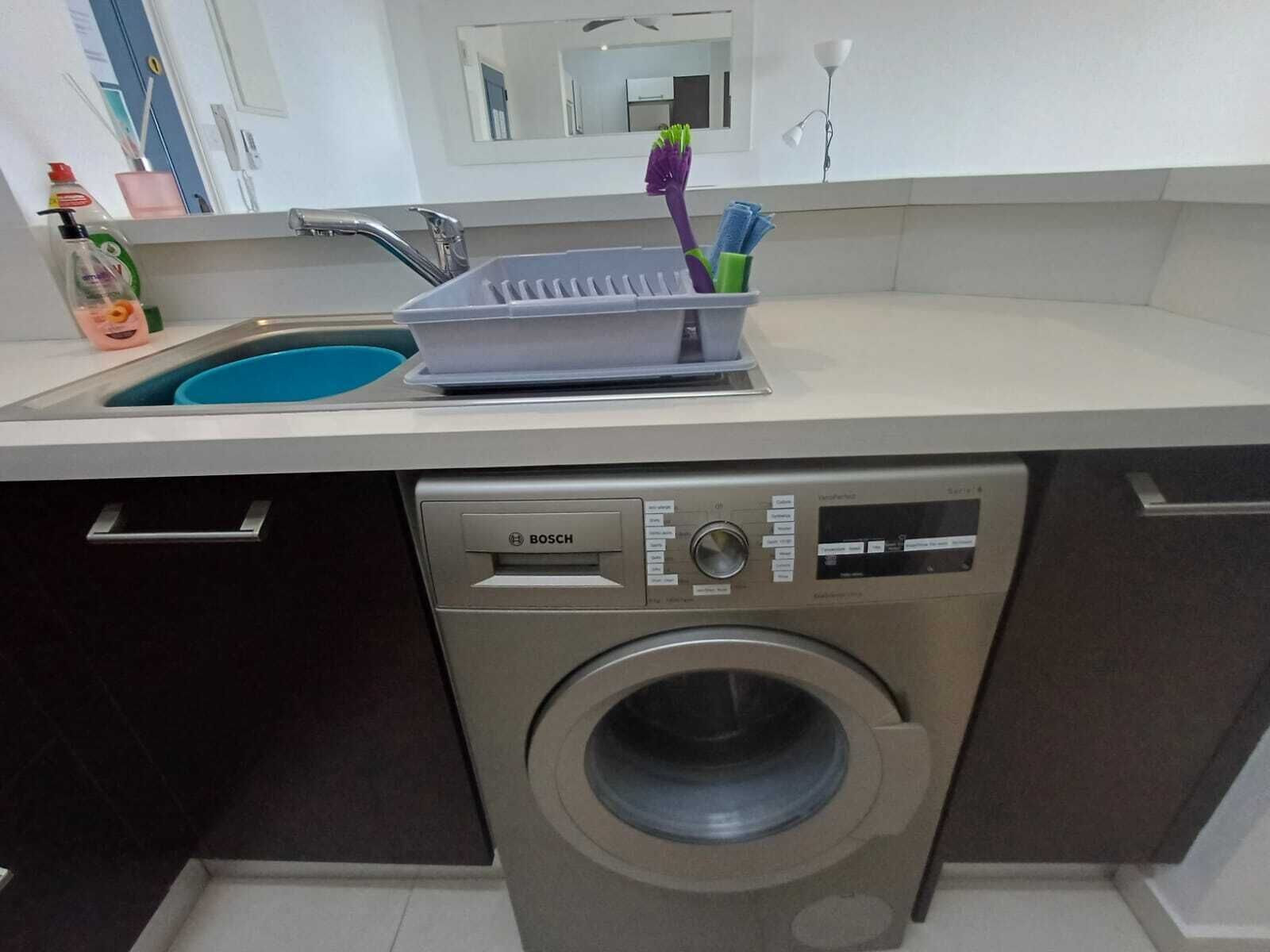 Una cocina compacta con lavavajillas Bosch y lavadora integrada.