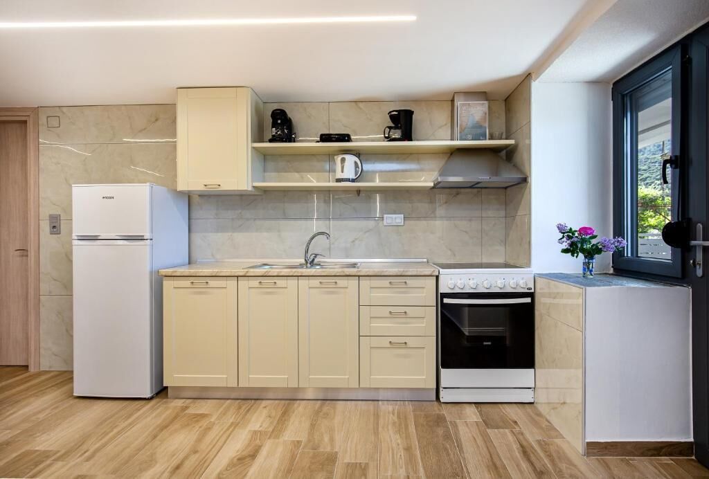 A modern kitchen with a built-in oven, a dishwasher, and a coffee maker on the countertop.