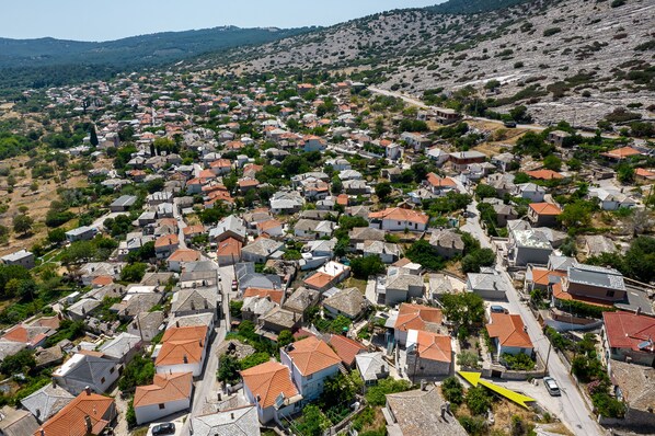 A densely packed residential area with closely built houses, narrow streets, and a hilly backdrop.