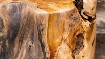 A close-up of a wooden table with a natural, uneven grain pattern.
