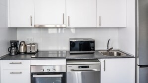 A modern kitchen with white cabinets, stainless steel appliances including a microwave, toaster, coffee maker, oven, dishwasher, and refrigerator. - Mijas Easy Flat With Pool - Ref 251 (Mijas)