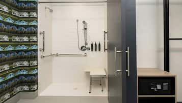 A modern bathroom with a shower, a toilet, and a vanity with a mirror.